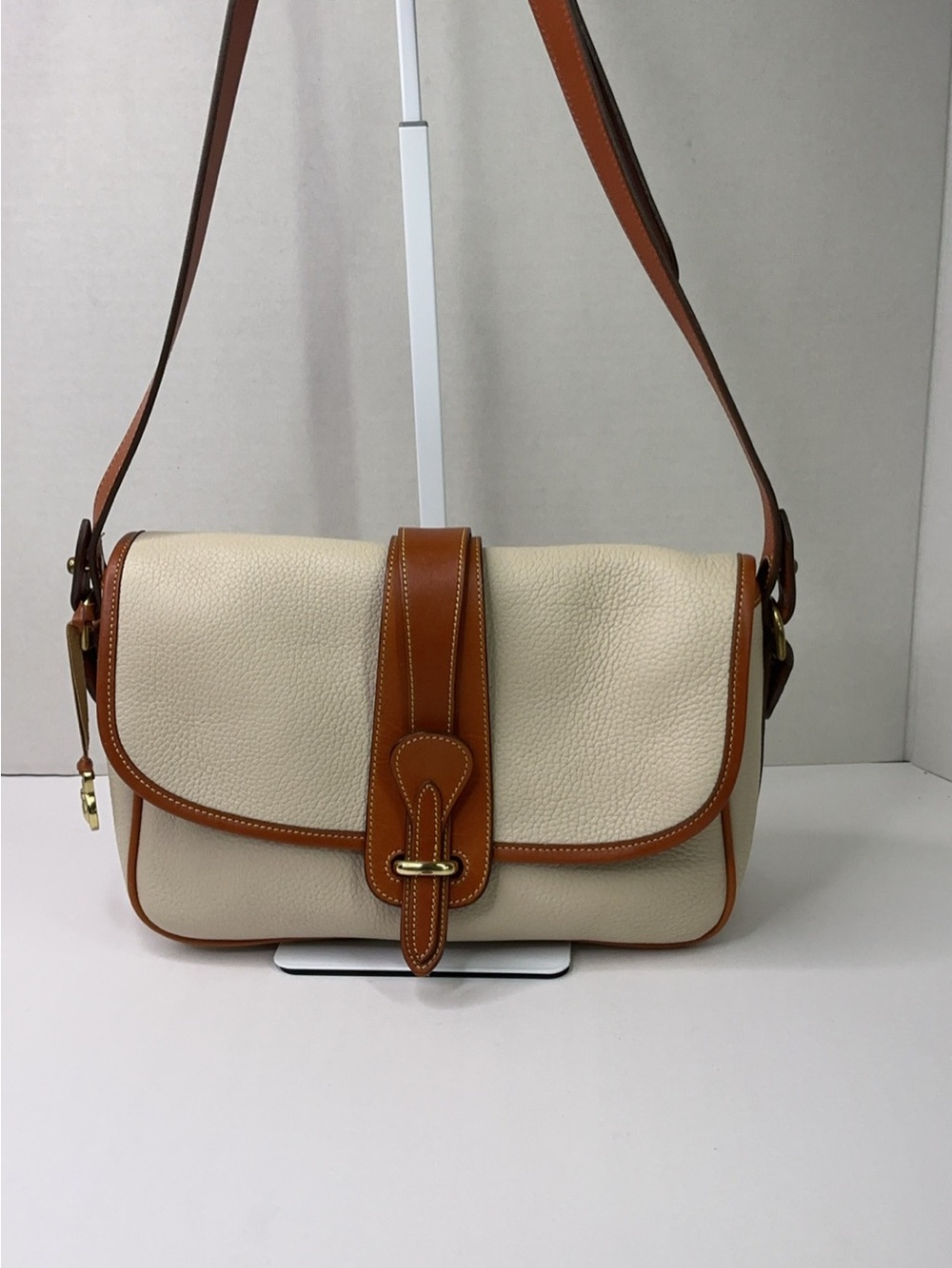 Dooney & Bourke cream and tan pebbled leather saddle bag